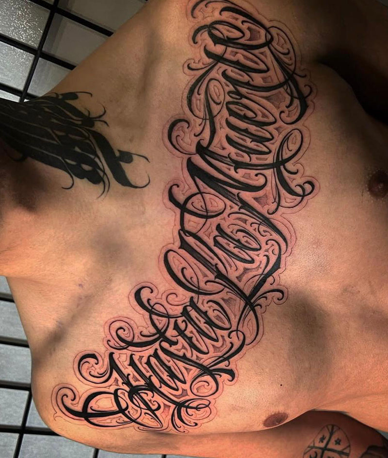 Script lettering chest tattoo by Wade Lucas